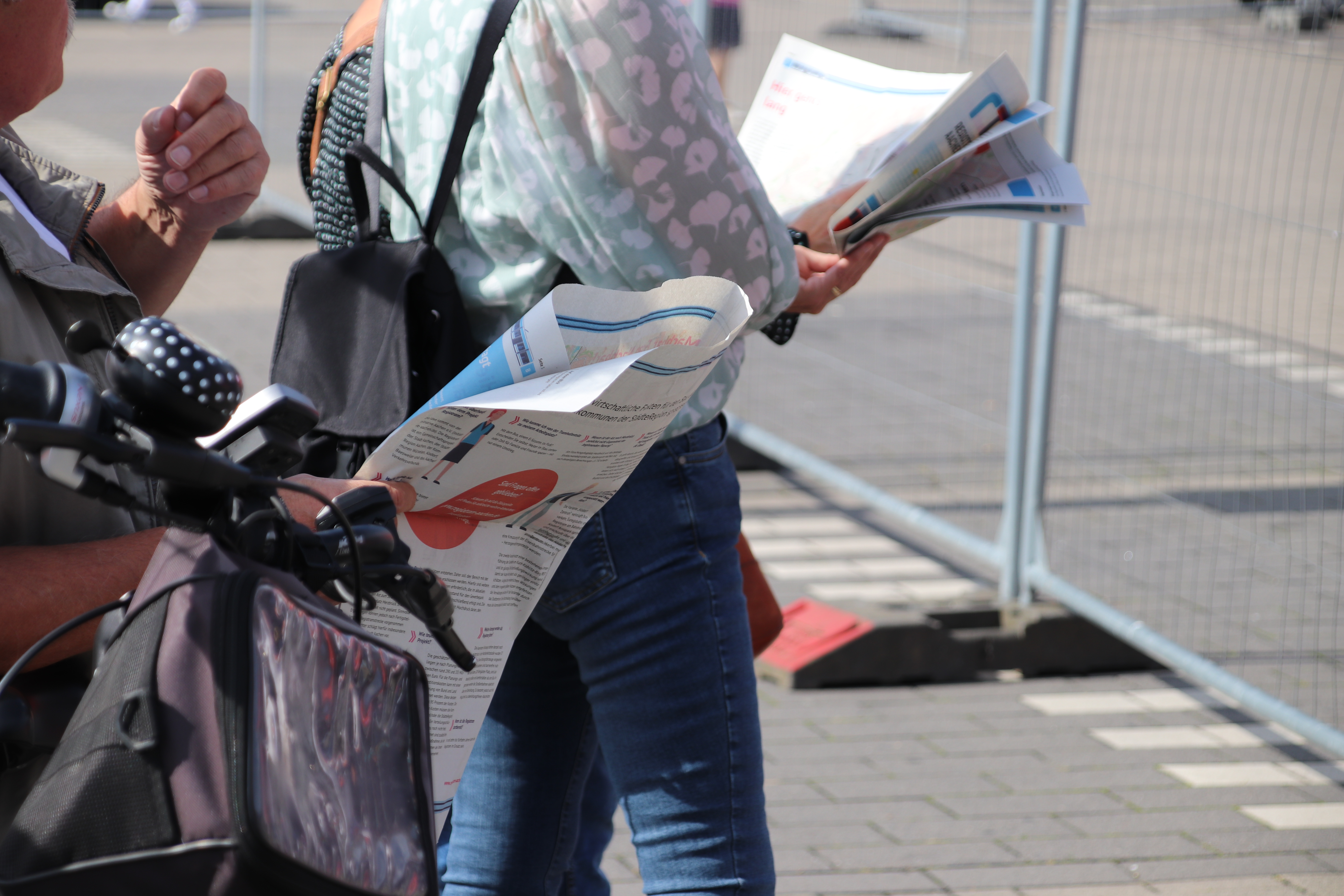 2 Personen lesen den Zeitungsbeileger zum Projekt